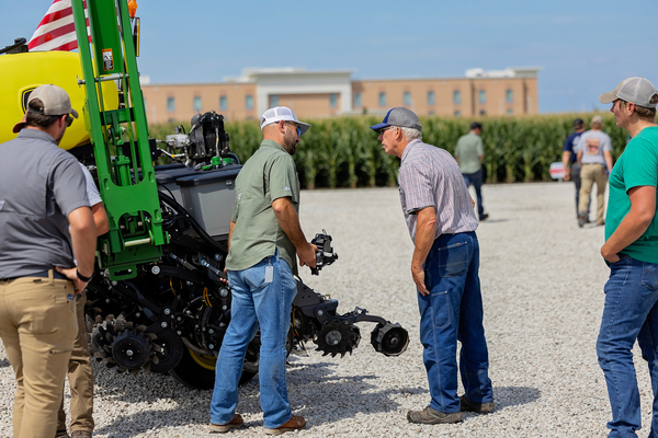Precision Planting employee explaining a planter part